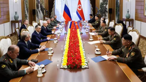 EPA Russian Defence Ministry delegation led by Minister Andrey Belousov (fourth on left), sit at table facing North Korean counterparts (on right) at talks in Pyongyang, 29 November