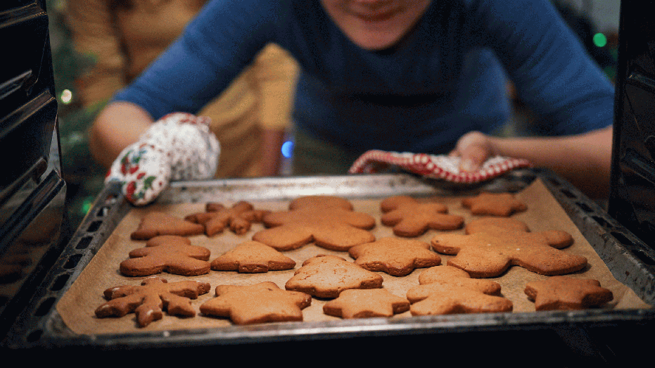 Teenage Girls Baking Christmas Cookies in the Oven