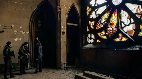 EPA Police inspect debris inside the St. Nicholas Roman Catholic Church in Kyiv