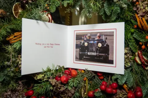 Getty Images Prince Charles's Christmas card from 2019, featuring the prince driving a classic sports car, with Camilla sitting in the front passenger seat. The message says: Wishing you a very Happy Christmas and New Year.