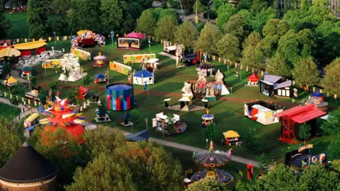 © Sabina Sarnitz. Courtesy Luna Luna LLC Luna Luna's rides and attractions from a birds eye view sit in a field.