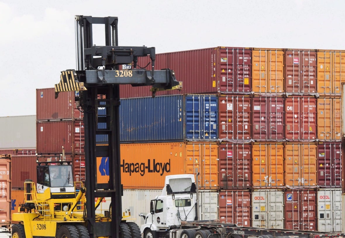 Containers are unloaded at the Port of Montreal in Montreal on July 20, 2017. The Canada Border Services Agency and the Port of Montreal are dipping their feet into a blockchain-powered technology that aims to streamline freight shipping and cut costs. In a trial run, the federal customs agency and the country's second-biggest port have signed on to the digital database -- a distributed ledger that shares and syncs up data from carriers, ports and wholesalers in places from Singapore to Peru. 