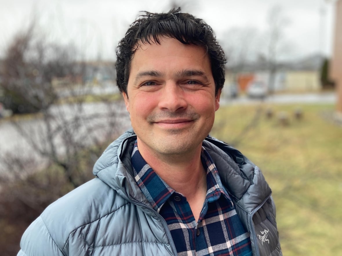 A man in a jacket poses for a photo