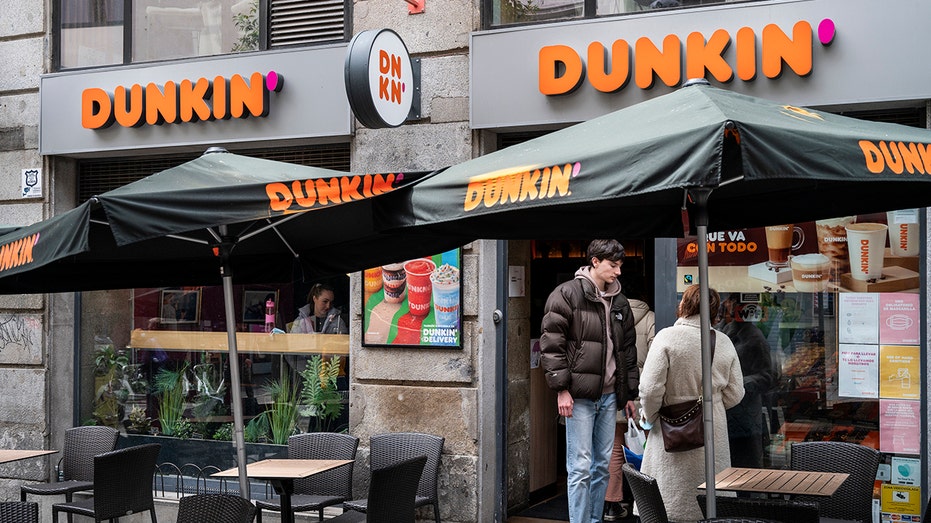 People standing in front of a Dunkin' store