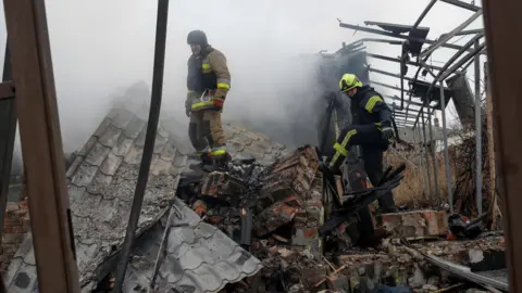 Reuters Firefighters work at the site of residential buildings hit by a Russian drone strike