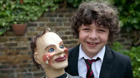 Hat Trick Productions Daniel Roche holding a ventriloquist doll