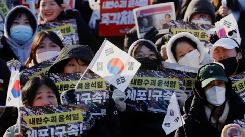 EPA Protesters  hold the South Korean flag and placards at a rally against South Korea's impeached President Yoon Suk Yeol, in the capital of Seoul. 