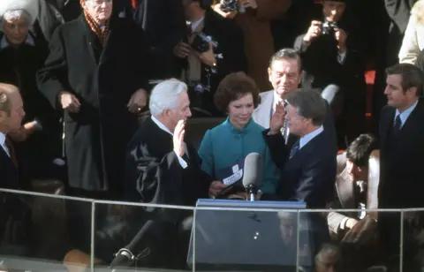 Corbis/Getty Images President Jimmy Carter takes the oath of office from Chief Justice of the Supreme Court Warren Burger on stage in front of the White House in January 1977