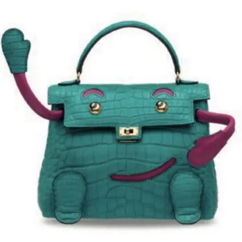 Met Police A green crocodile skin handbag with red arms and a smiley face as part of the design. 