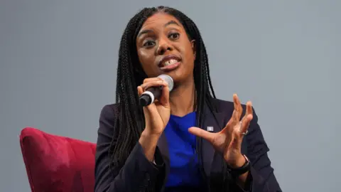 PA Media Kemi Badenoch speaks into a microphone at the Business Property Relief summit at the London Palladium