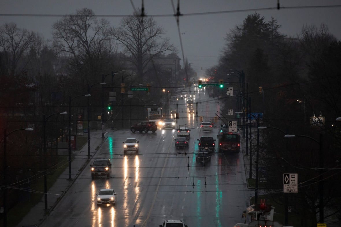 Cars and buses share the road during a period of significant rain.