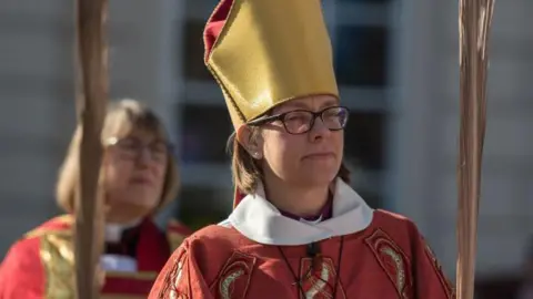 Getty Images Bishop of Newcastle Helen-Ann Hartley wearing red robes and a yellow hat