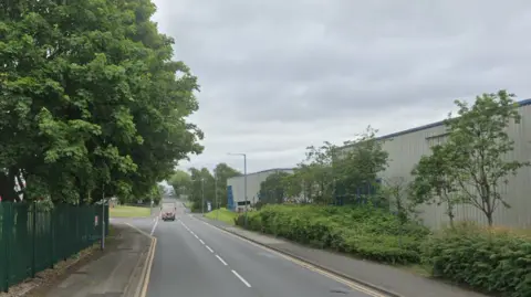 Google Dartmouth Road, an industrial street lines with green trees and bushes