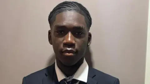 Detained in Dubai Marcus Fakana in school uniform looks directly at the camera with his head against a grey backdrop.
