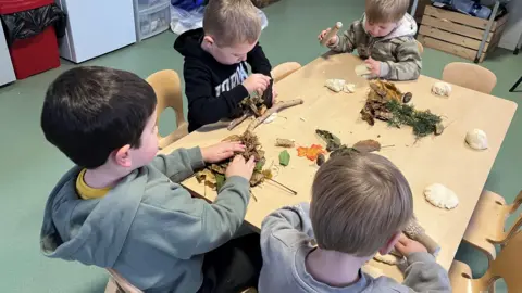 BBC Small children working at a nature project on a table in a nursery