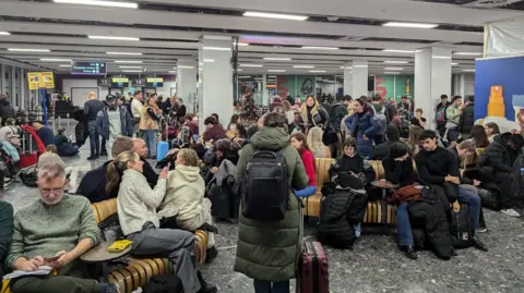 BBC A crowd of passengers at Edinburgh Airport