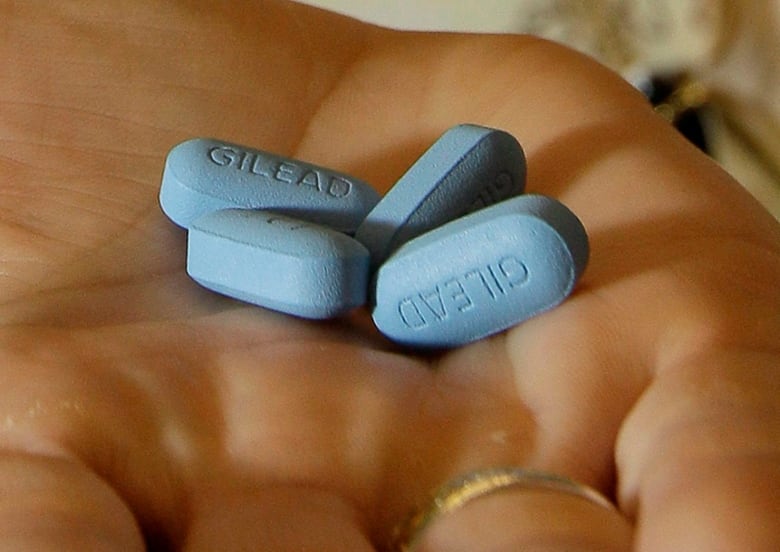 A close up of blue pills held in someone's hand.