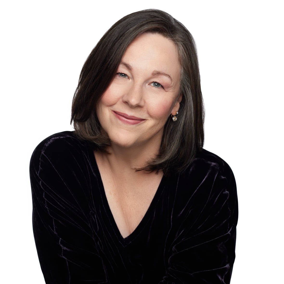 A woman with bob-length dark hair is smiling at the camera. 