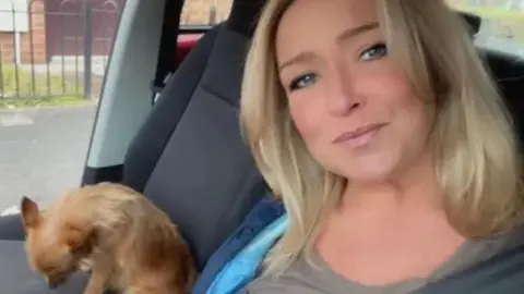 Family handout Teresa McMahon, with long blonde hair and blue eyes, smiles as she sits in a car alongside a chihuahua dog.