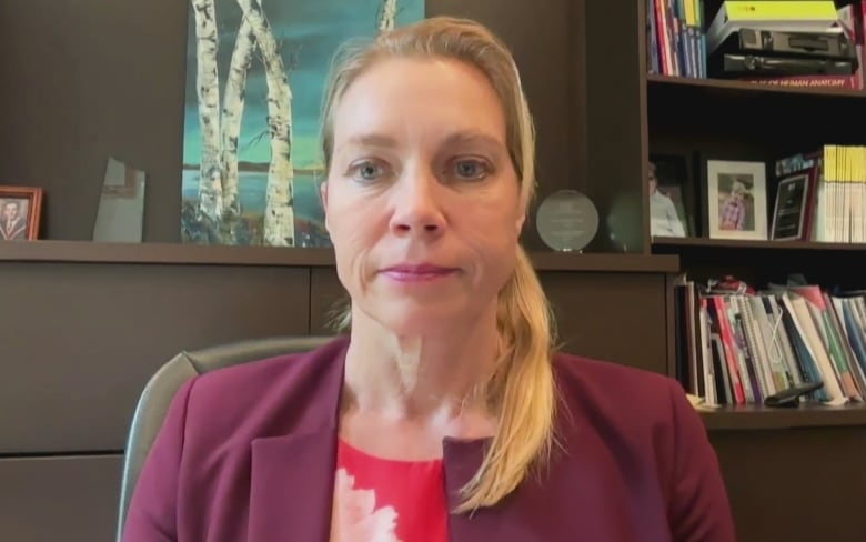 Woman in office in purple blazer.