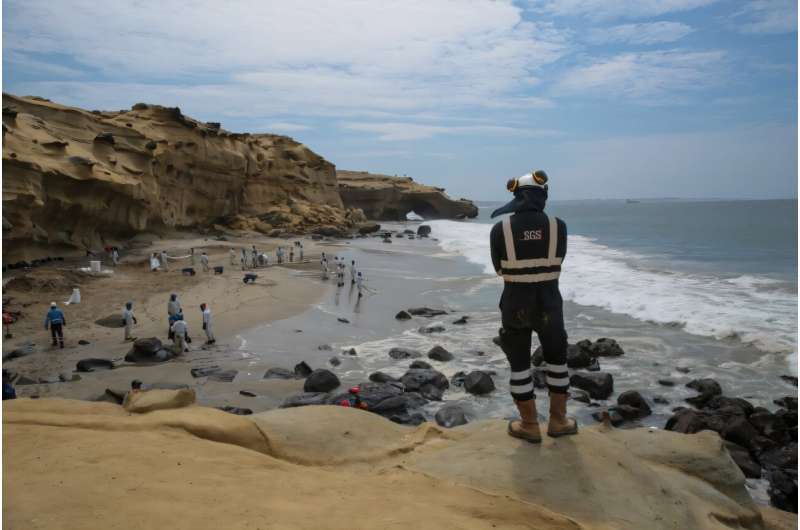 A picture released by the NGO Coast 2 Coast Movement shows workers cleaning up Peru's Las Capullanas beach after an oil spill