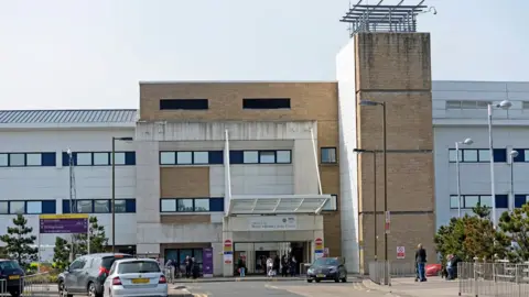 Getty Images The outside of the Royal Infirmary of Edinburgh, with a number of cars and pedestrians.