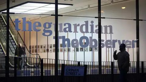 Getty Images Man walks past The Guardian and The Observer's office in King's Cross, London