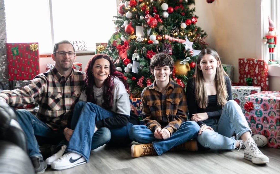 A family sitting in front of a christmas tree