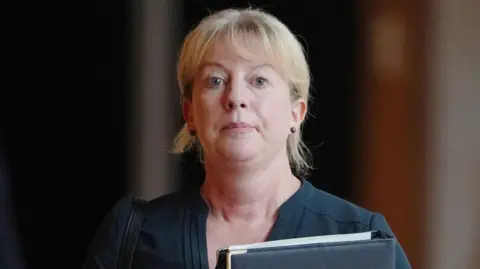 PA Media Shona Robison, head and shoulders pic, looking serious holding a folder