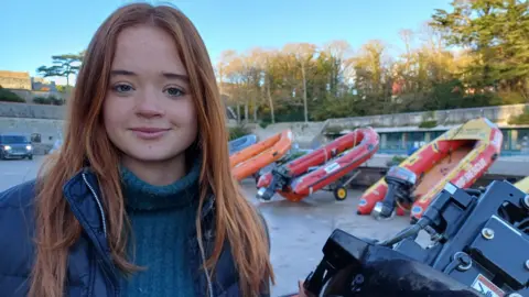 BBC Student, Efa, is pictured alongside rigid-hull inflatable boats used in search and rescue operations 