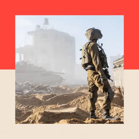 BBC A soldier in uniform stands amidst rubble in the Gaza Strip, his back turned to the camera