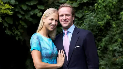 Reuters Lady Gabriella wearing a blue dress smiling as she stands next to her husband Thomas Kingston who is wearing a navy-coloured suit.