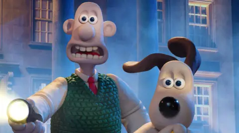 BBC/Aardman Animations/Richard Davies/Stuart Collis Wallace & Gromit in Vengeance Most Fowl, running away from something with Wallace holding a torch