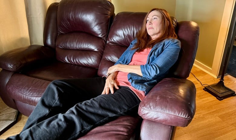 A woman lays on a recliner chair.