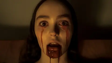 Universal Pictures Lily-Rose Depp as Ellen Hutter in Nosferatu with blood seeping out of her mouth and across her face