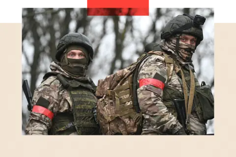 Reuters Two soldiers in combat gear carrying lots of equipment 