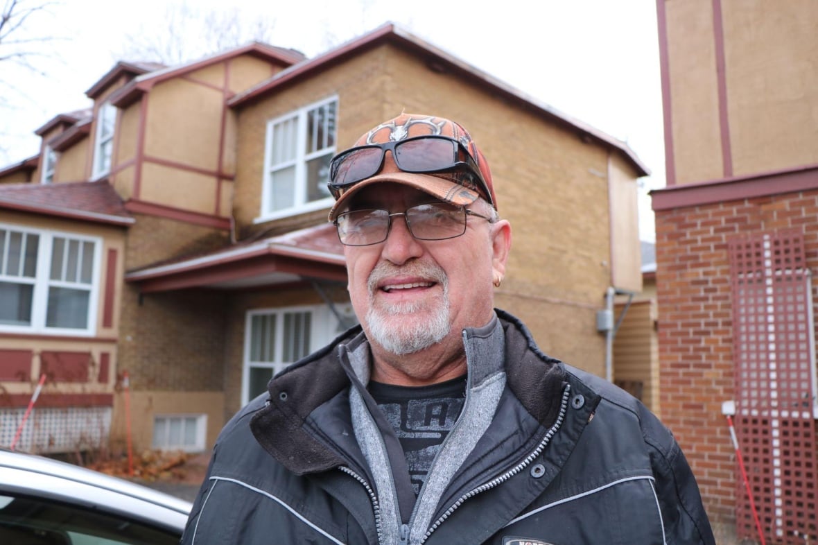 A man smiling outside of a building.