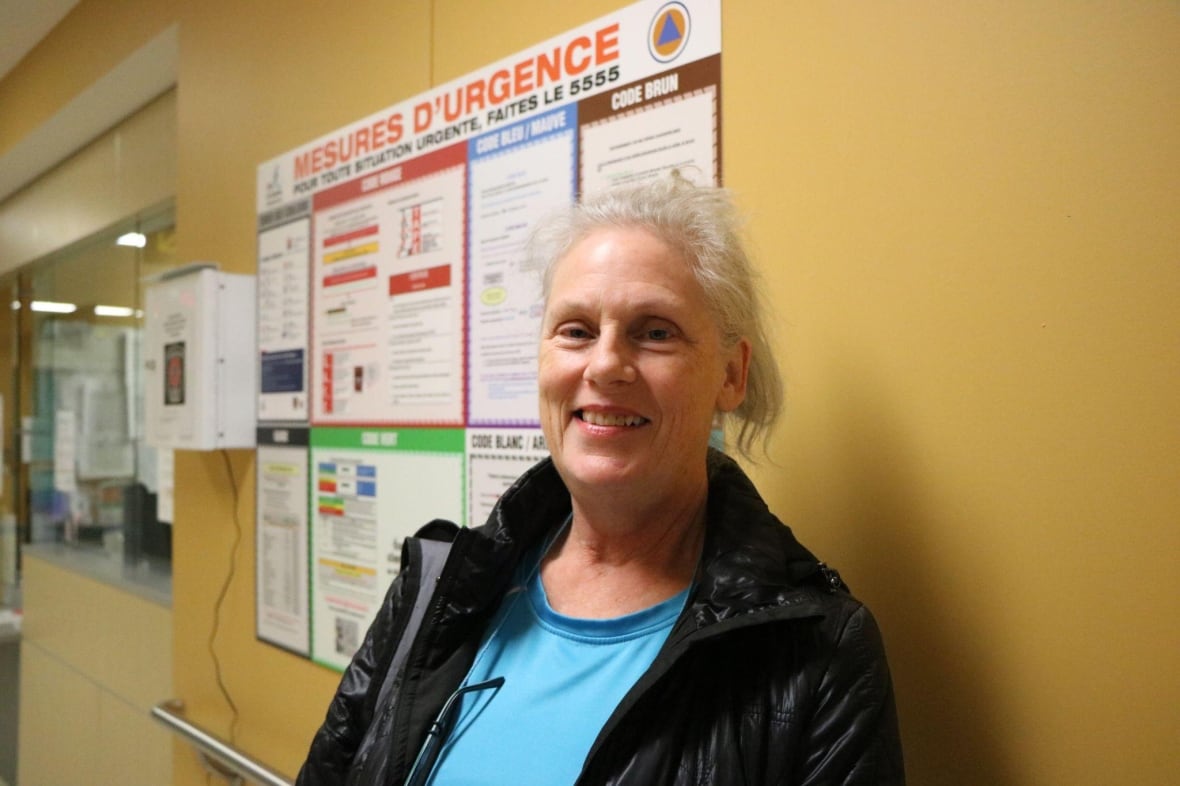 A woman smiling inside of a hospital. 