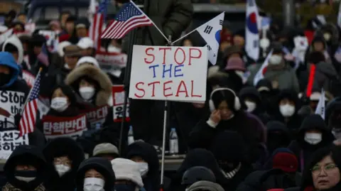 Reuters Yoon's supporters hold a banner reading "Stop the steal", as well as South Korean and US flags