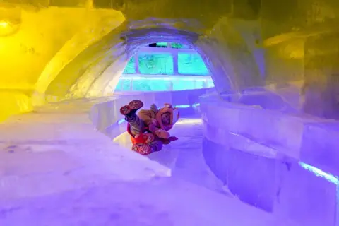 Zhao Yuhang/China News Service/Alamy A child slides inside an ice sculpture at the 51st Harbin Ice Lantern Art Fair on 30 December 2024 in Harbin, Heilongjiang province.