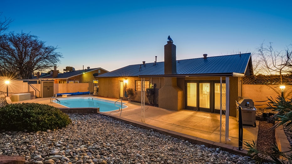 The backyard features a swimming pool with a diving board.