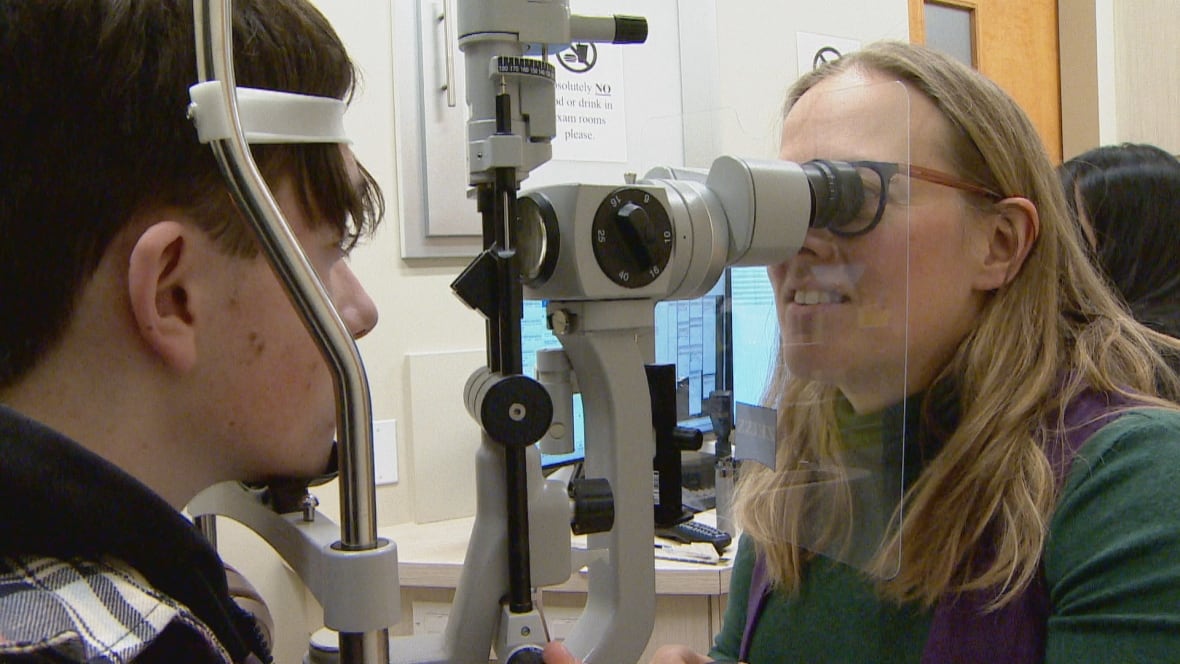 An ophthalmologist conducts an eye exam on a boy.  