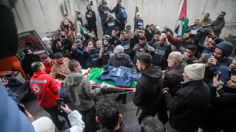 Getty Images Palestinian mourners and journalists carry the body of Shatha al-Sabbagh, a journalism student, outside Jenin Governmental Hospital