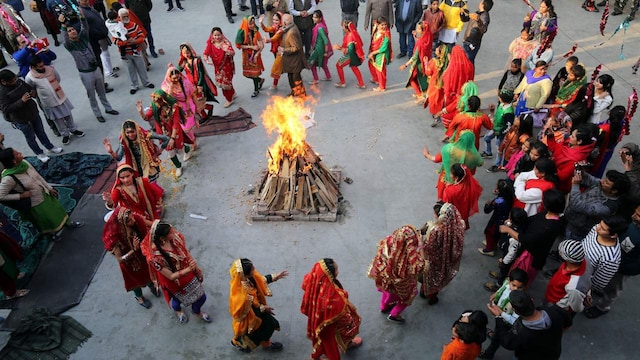 3. Lohri | Celebrated across several states in India, especially Punjab, this harvest festival sees people lighting bonfires and dancing to welcome the longer days ahead after the winter solstice. This year, Lohri is being marked on Monday, January 13. The Lohri celebrations are extra special in families where a marriage or a birth has taken place recently. During this occasion, people offer jaggery, gachak and rewri to each other. (Image: Reuters)