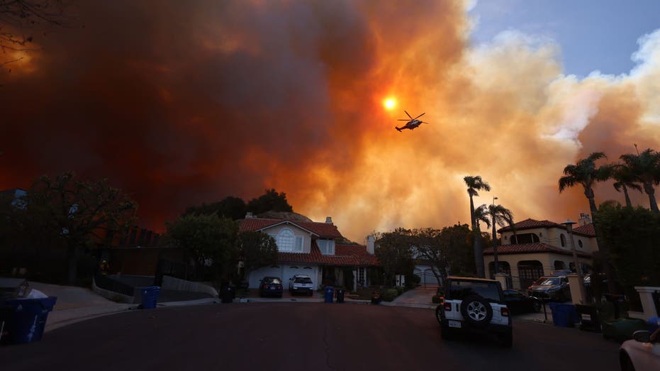 TOPSHOT - Plumes of smoke are seen as a brush fire burns in Pacific Palisades, California on January 7, 2025. A fast-moving brushfire in a Los Angeles suburb burned buildings and sparked evacuations Tuesday as "life threatening" winds whipped the region. More than 200 acres (80 hectares) was burning in Pacific Palisades, a upscale spot with multi-million dollar homes in the Santa Monica Mountains, shuttering a key highway and blanketing the area with thick smoke. (Photo by David Swanson / AFP) (Photo by DAVID SWANSON/AFP via Getty Images)