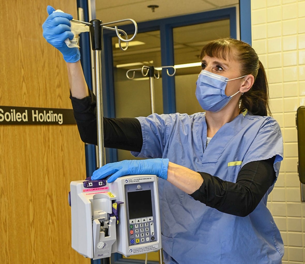 A staff member cleans an IV pole.