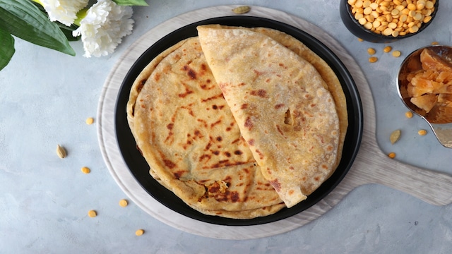 Puran Poli | The Maharashtrian dish puran poli is a delectable dish. It is a sweet flatbread filled with crumbly moong dal mixed with jaggery inside. Besides being the traditional dish for Makar Sankranti, it is one of the favourite breakfast options in Maharashtra. (Image: Shutterstock)