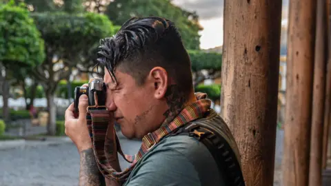 Fritz Pinnow Steven López looks through the viewfinder of his analogue camera in Antigua, Guatemala.