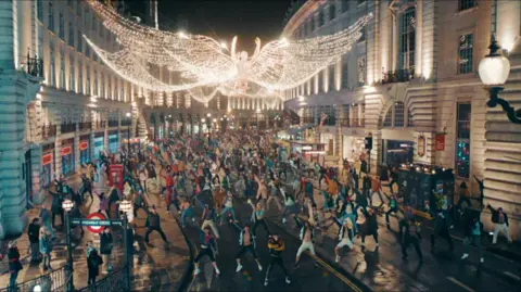 Entertainment A scene from Better Man shows hundreds of dancers performing on London's Regent Street