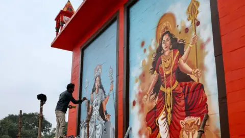 Getty Images A man paints murals of Hindu deities on the Alopi Devi temple wall, ahead of the Maha Kumbh Mela festival in Prayagraj on December 31, 2024. (Photo by Niharika KULKARNI / AFP) (Photo by NIHARIKA KULKARNI/AFP via Getty Images)